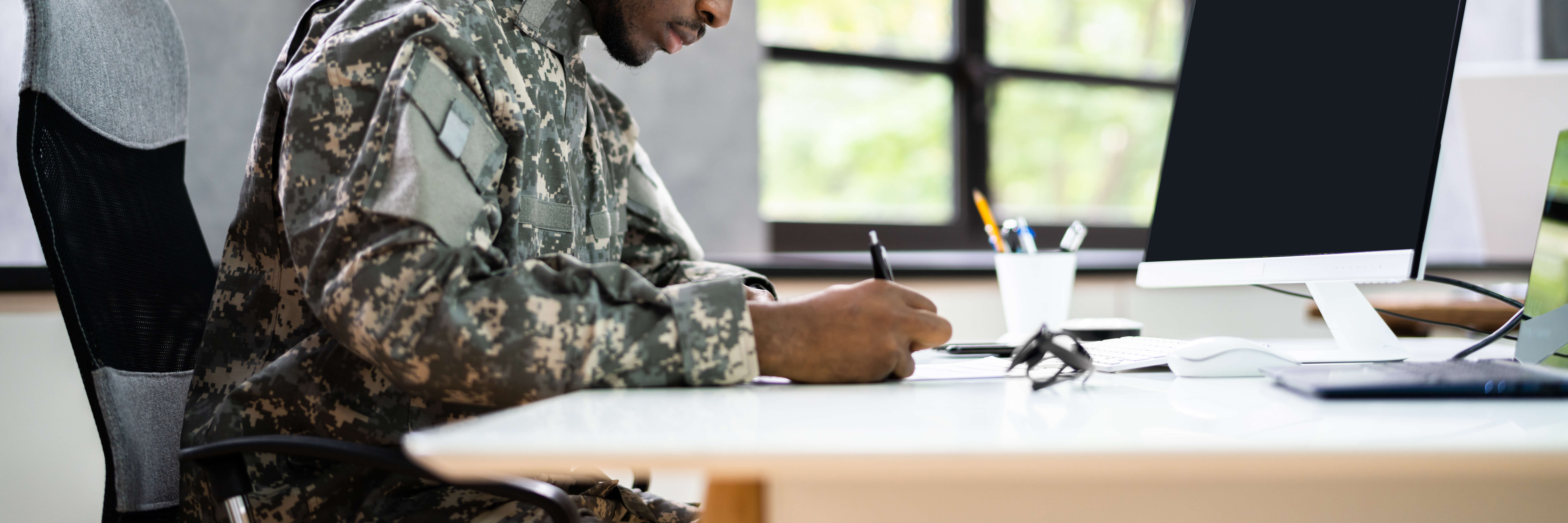 Military Person writing at a desk